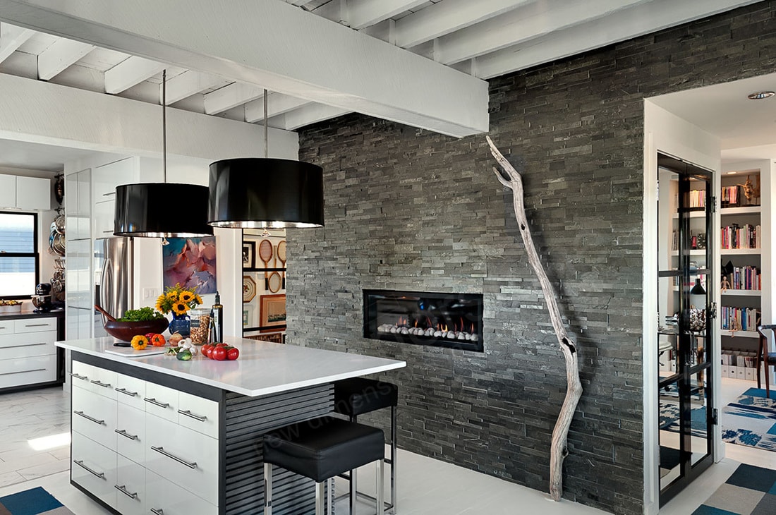 Charcoal Stone Veneer Wall in Kitchen with a ventless gas fireplace and tree branch art